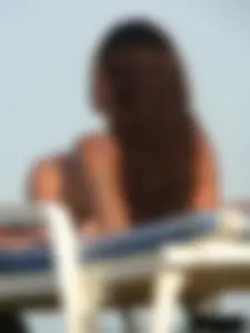 Topless tattooed lady on the beach with fake big tits
