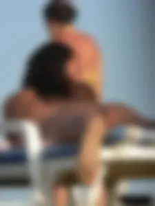 Topless tattooed lady on the beach with fake big tits