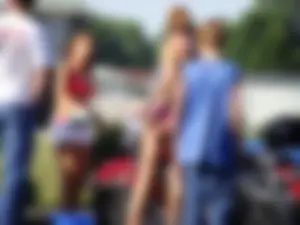 Group of cute girls at a car wash in bikinis and shorts