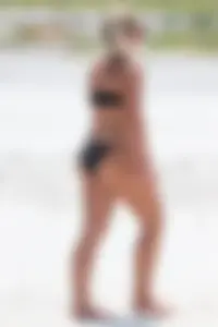 Beach blonde in the water in black bikini with a nice ass and small boobs