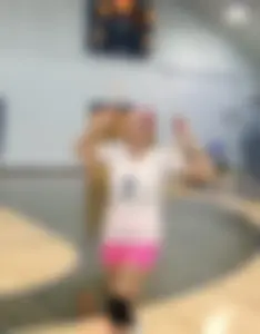 Bunch of cute college girls in bright pink shorts playing volleyball