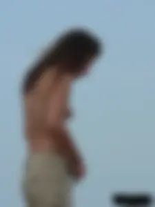 Sexy babe with a nice body topless and in a thong on the beach