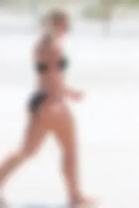 Beach blonde in the water in black bikini with a nice ass and small boobs