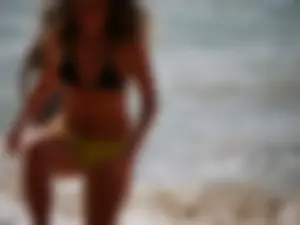 Sexy girl in yellow and black bikini on the beach