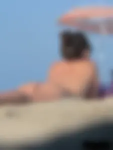 Sexy babe with a nice body topless and in a thong on the beach