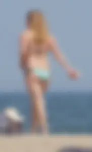 Cute girls in light blue and purple bikinis on the beach