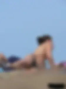 Sexy babe with a nice body topless and in a thong on the beach