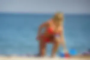 Hot blonde with a slammin body in red thong bikini on the beach
