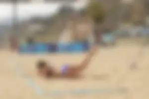 Sexy beach volleyball girl in sport bra top with pokies and blue bikini bottom