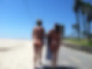 Two sexy girls with nice asses in bikinis walking on a beach trail