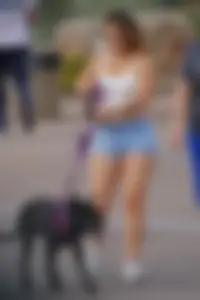 Sexy dog walker in shorts and tank top with friend in blue jeans