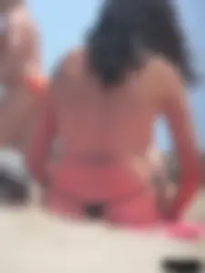 Brunette lady topless and in a black thong on the beach