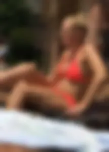 Sexy blonde lady in a bikini with a great body laying by the pool