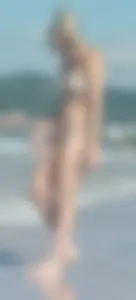 Smooth bodied and sexy blonde at the beach in a thong bikini