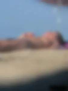 Sexy babe with a nice body topless and in a thong on the beach