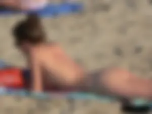 Sexy babe with a nice body topless and in a thong on the beach