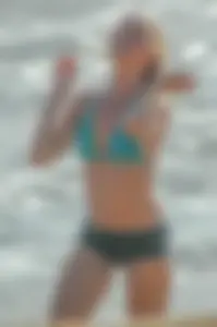 Blonde lady on the beach in bikini top and spandex shorts with a nice gap