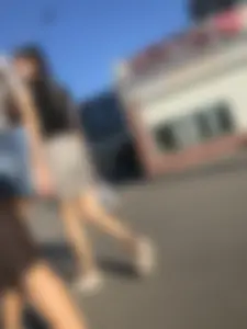 Two Hot Girls on a Street in Denim Shorts and a Skirt - One Touching Her Booty - Creepshots Gallery