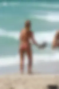 Topless girl in a tiny thong on the beach playing paddle ball