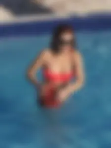 Sexy red haired girl in pink and black bikini at the pool