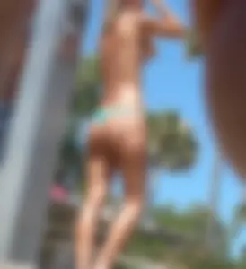 Hot ass blonde babe on the beach topless and in a little thong with a great ass