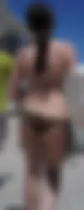 Girl in a tiny brown floral bikini showing some cheek and crack