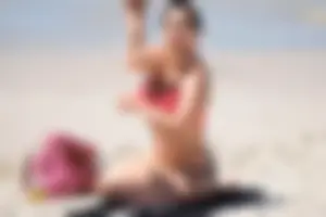 Huge boobed thick brunette babe on the beach in a bikini