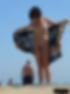 Topless beach milf looking sexy in a tiny g-string bikini