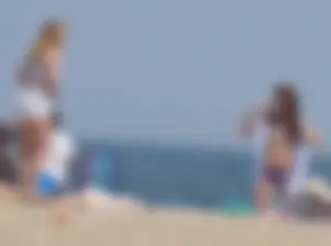 Cute girls in light blue and purple bikinis on the beach