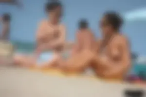 2 topless girls at the beach in thongs