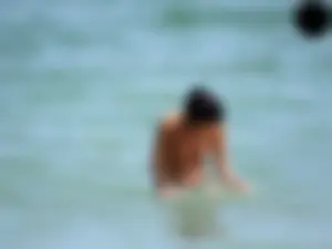 Brunette topless babe with cute tits and a nice ass in a thong bikini