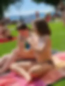 Young Candid Girl in a Swimsuit Sitting With Crossed Legs on the Grass at the Beach Creepshots