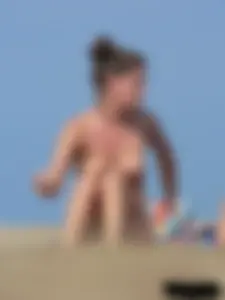 Sexy babe with a nice body topless and in a thong on the beach