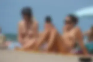 2 topless girls at the beach in thongs