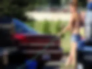 Group of cute girls at a car wash in bikinis and shorts