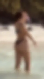 Candid girl in swimsuit standing in sea water creepshot