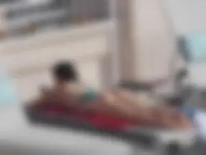 Sexy ass brunette sunbathing by the pool in thong bikini