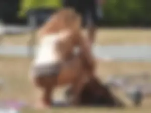 Lady at the park stripping down to her bikini to lay out