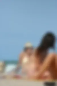 2 topless girls at the beach in thongs