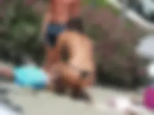 Sexy girl on the beach getting some sun in a little black thong bikini
