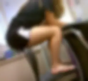 Student girl in shorts and slippers sitting on a back of a chair