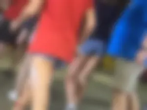 Bunch of girls in various outfits at a Cardinals baseball game