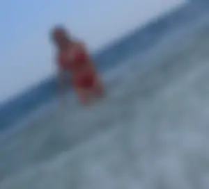 Sexy girl at the beach in a red thong bikini with nice tits and ass