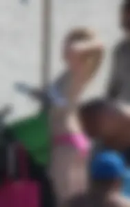 Skinny blonde girl on the beach in her pink and white bikini