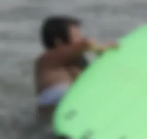 Brunette bikini girl on the beach and surfing in her bikini