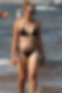 Strawberry blonde sexy mature girl walking the beach in black bikini