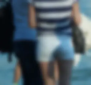 Hot Tanned Legs in White Denim Shorts on the Beach Closeup Photos
