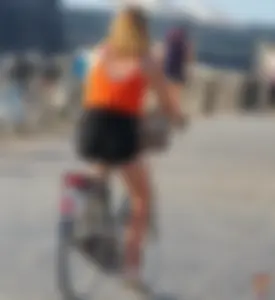 Blonde in black shorts getting on a bike