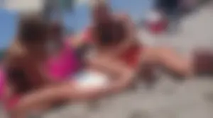 Girls hanging out together at the beach in bikinis and thongs