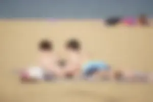 Sexy girl on the beach laying out and bending over in her bikini
